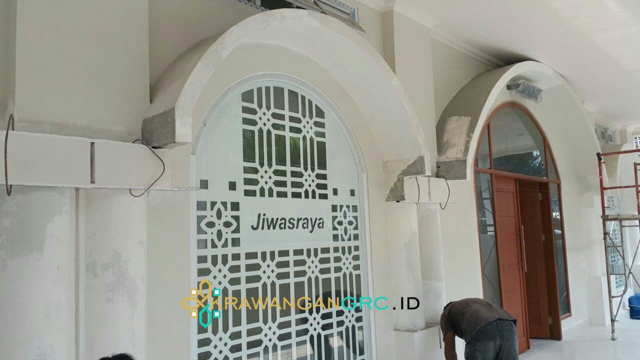 Krawangan GRC berlogo Jiwasraya pada lengkung pintu masuk gedung